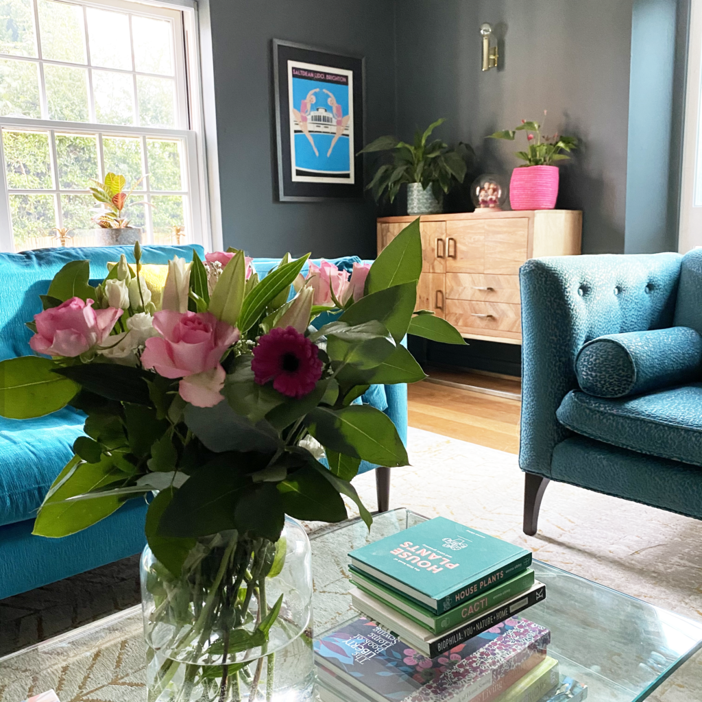 teal sofa in living room, dark grey walls, abstract art